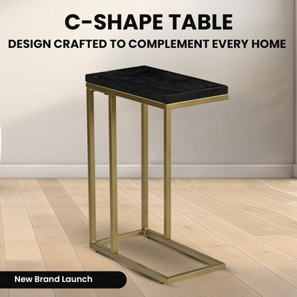 C-förmiger Beistelltisch aus schwarzem Mangoholz mit goldfarbenem Metallrahmen auf Parkettboden