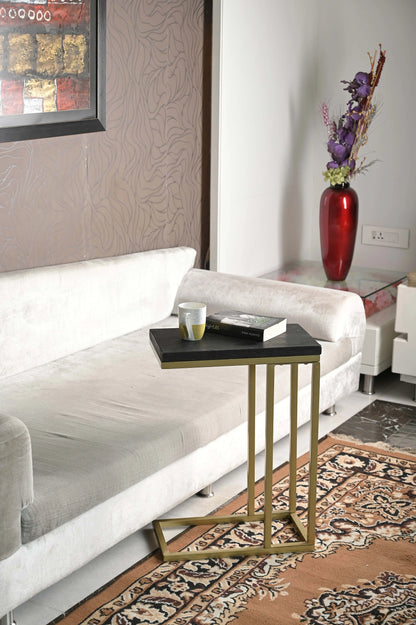 Moderner Sofatisch aus Mangoholz neben grauem Sofa, dekoriert mit Tasse und Buch, Blumen in roter Vase