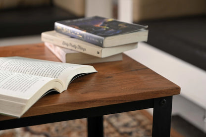 Nahaufnahme eines handgefertigten Mangoholz-Tisches mit Büchern, nachhaltige Möbel Deko